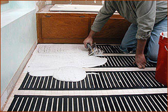 Applying thinset over the polyethylene FloorHeat STEP floor heating element.