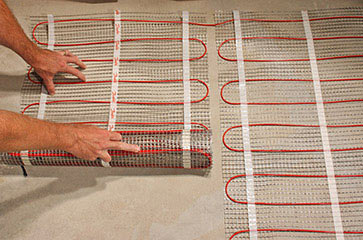 Installing floor heating mat.