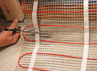 Cutting the mesh backing of floor heating mat.